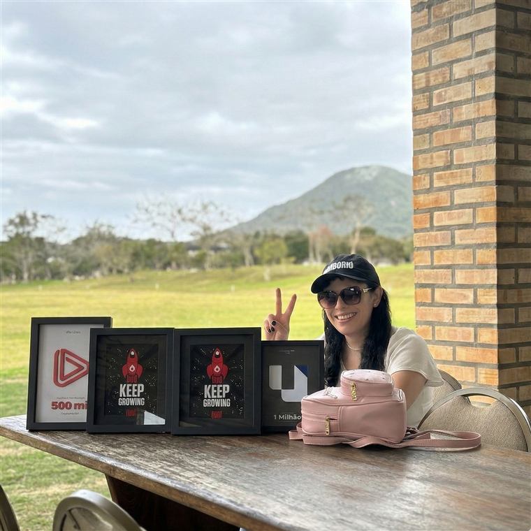 Nicole ao lado de reconhecimentos conquistados com seu trabalho